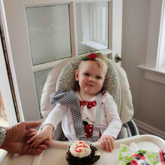 June's 2nd birthday in high chair with cake