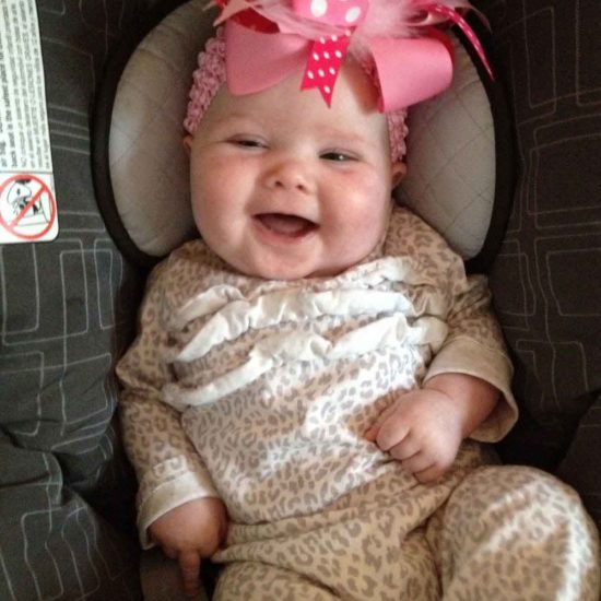 Baby June smiling with big pink bow