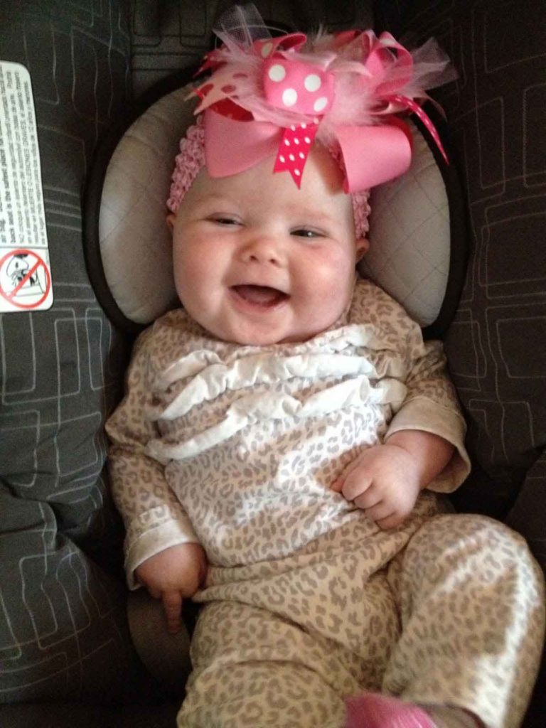 Baby June smiling with big pink bow